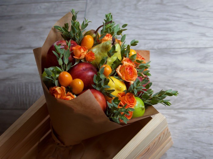 A bouquet with flowers and fruit.